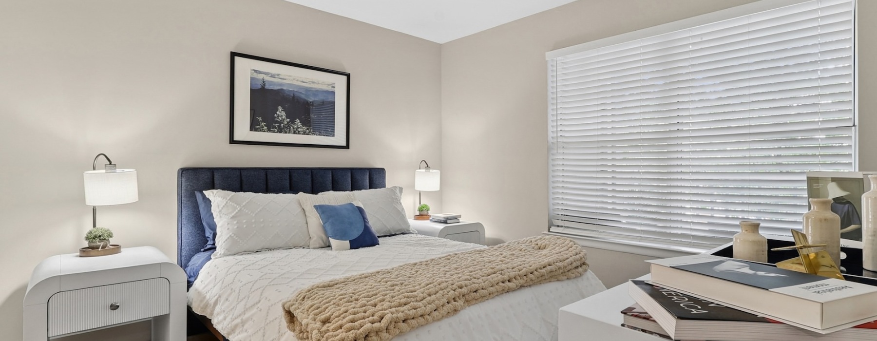Model bedroom at Arbors on Duke Apartments in Alexandria, VA, featuring carpeted flooring and windows with blinds.