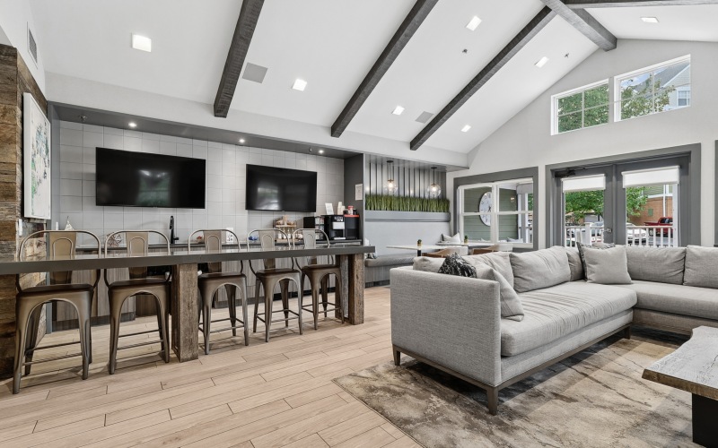 Clubhouse with large tv's, bar and couch seating
